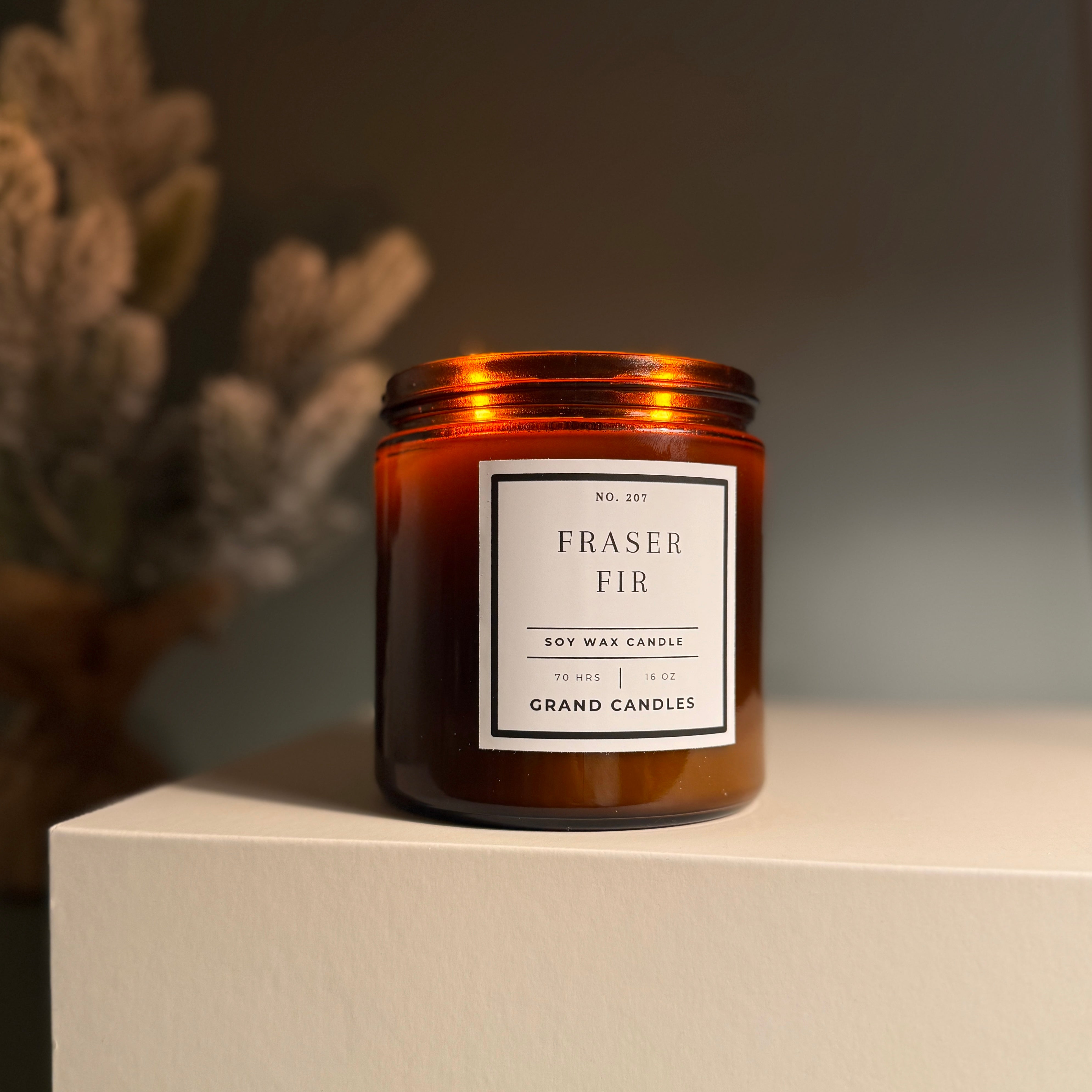 Scented candle labeled 'Fraser Fir' by Grand Candles on a neutral background